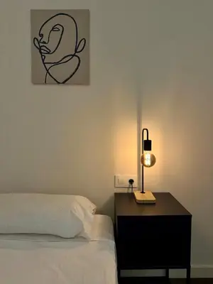 a bedroom with a bed and a table with a lamp at Spacious 1 br home in Bonanova in Barcelona