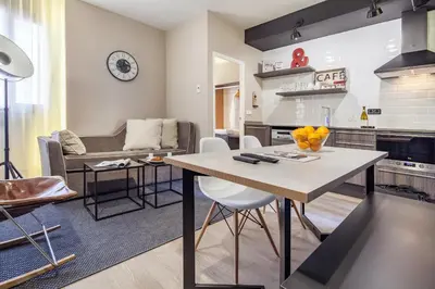 a kitchen and living room with a table and a couch at Habitat Apartments Cool Jazz in Barcelona