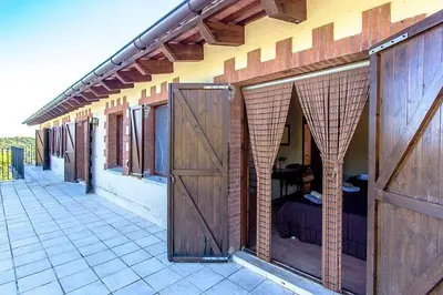 a man sleeping in a bed in a building with wooden doors at Casa Rural CAN PANXA in Sant Pere de Vilamajor