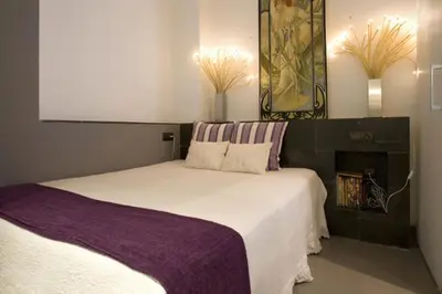 a bedroom with a large white bed with purple sheets at City Center Apartment in Barcelona