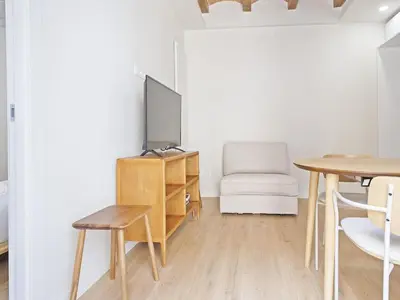 a living room with a table and a tv and a chair at Winahost La Barceloneta in Barcelona