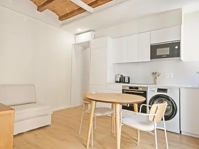 a kitchen with a table and chairs in a room at Winahost La Barceloneta in Barcelona