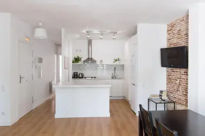 a white kitchen with a white island in a room at Central Apartment in Barcelona