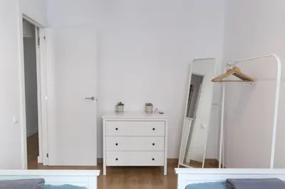 a white bedroom with a dresser and a mirror at Central Apartment in Barcelona