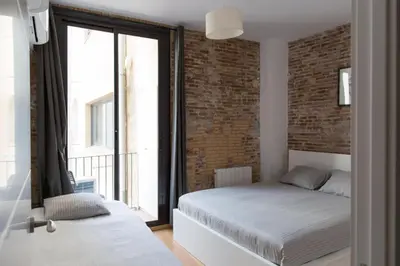 a bedroom with a bed and a brick wall at Central Apartment in Barcelona