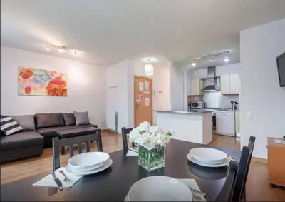 a kitchen and a living room with a table and a couch at Central Apartment in Barcelona