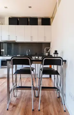 a kitchen with a table and two stools at Nice apartment in Gracia - Torrent de l'Olla in Barcelona