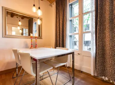 a dining room with a table and chairs and a window at Blasco de Garay: acogedor apartamento en el corazón de Poble-sec in Barcelona