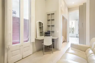 a living room with a white couch and a desk at Suites4days Ali bei Apartment in Barcelona