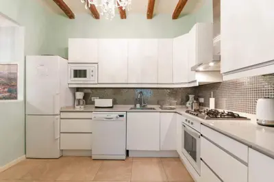 a kitchen with white appliances and white cabinets at Explore City Center from an Elegant Urban Retreat in Barcelona