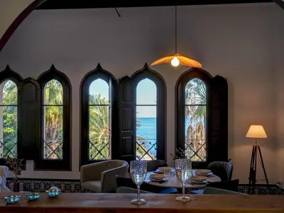 a dining room with a table and a group of windows at Las Ventanas Sea Front by Hello Homes Sitges in Sitges
