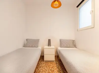 two twin beds in a room with a window at Tapioles · Lovely apartment in Poble Sec in Barcelona