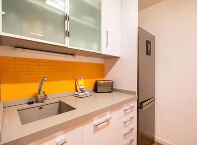 a kitchen with a sink and an orange wall at Tapioles · Lovely apartment in Poble Sec in Barcelona