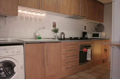 a kitchen with wooden cabinets and a washer and dryer at Urgell - Lovely apartment with a terrace in Barcelona