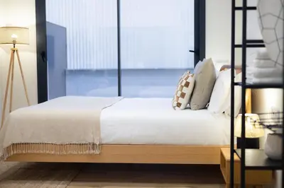 a bedroom with a bed with white sheets and pillows at Stay U-nique Apartments Font BCN in Hospitalet de Llobregat