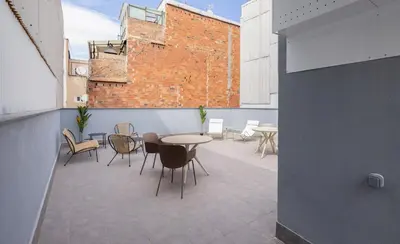 a balcony with a table and chairs on a building at Stay U-nique Apartments Font BCN in Hospitalet de Llobregat
