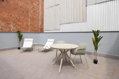 a table and chairs in a room with a brick wall at Stay U-nique Apartments Font BCN in Hospitalet de Llobregat