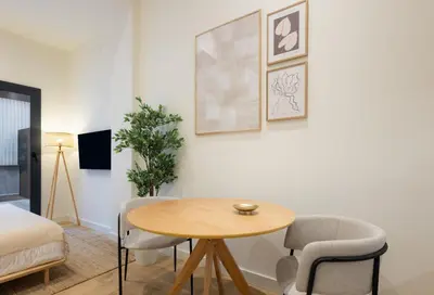 a room with a table and chairs and a bed at Stay U-nique Apartments Font BCN in Hospitalet de Llobregat