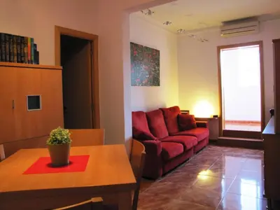 a living room with a red couch and a table at FlexCo City - Barcelona Flats in Barcelona