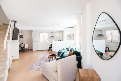 a living room with a white couch and a mirror at Casa Jasmine Family Villa near the beach in Barcelona