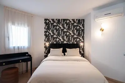 a bedroom with a large bed and a piano at Casa Jasmine Family Villa near the beach in Barcelona