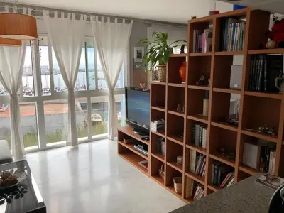 a living room with a book shelf with a television at Loft en Arenys de Mar in Arenys de Mar