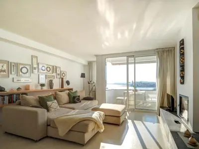 a living room with a couch and a large window at Sunset apartment by Hello Homes Sitges in Sitges
