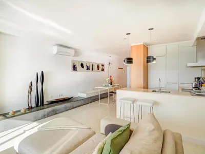 a living room with a couch and a kitchen at Sunset apartment by Hello Homes Sitges in Sitges