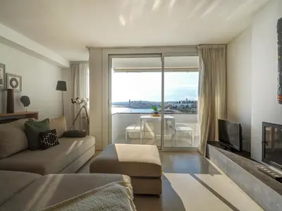 a living room with a couch and a large window at Sunset apartment by Hello Homes Sitges in Sitges