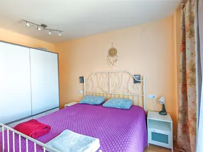 a bedroom with a purple bed and a balcony at Modern Apartment near the sea in Pineda de Mar