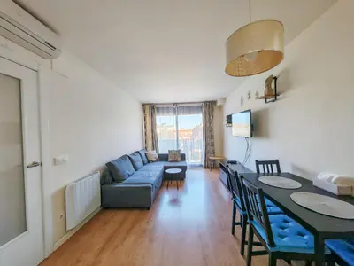 a living room with a blue couch and a table at Modern Apartment near the sea in Pineda de Mar