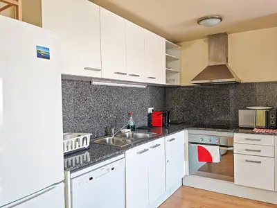 a kitchen with white cabinets and a sink at Modern Apartment near the sea in Pineda de Mar