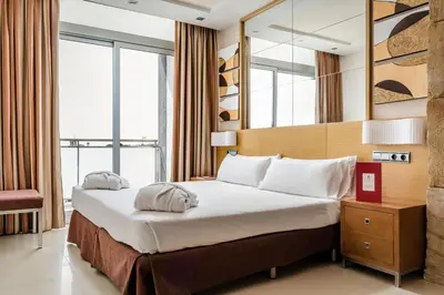 a hotel room with a bed and a mirror at Exe Cunit Suites & Spa in Cunit