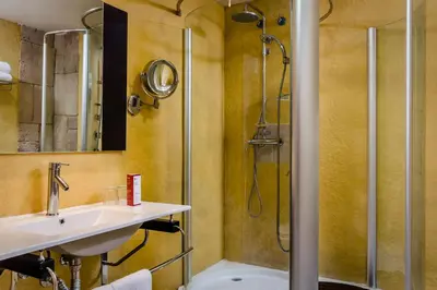 a bathroom with a sink and a shower at Exe Cunit Suites & Spa in Cunit