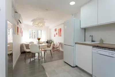 a kitchen with white appliances and a table with chairs at Key Barcelona Diagonal Mar in Barcelona