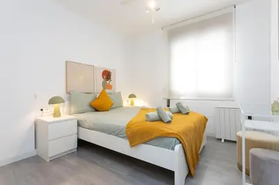 a white bedroom with a bed and a window at Key Barcelona Diagonal Mar in Barcelona