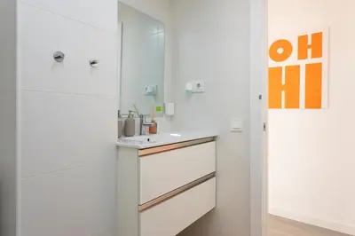 a kitchen with white cabinets and an orange sign on the wall at Key Barcelona Diagonal Mar in Barcelona