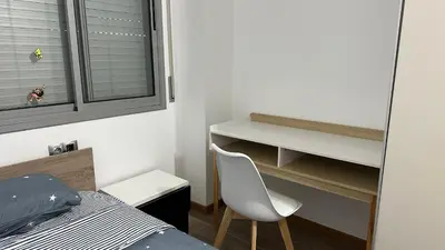a bedroom with a bed and a desk and a chair at Apt compartido martirrena in Badalona