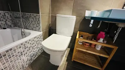 a bathroom with a white toilet and a bath tub at Apt compartido martirrena in Badalona