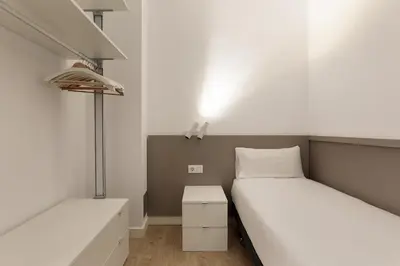 a bedroom with two beds and a lamp in it at Ola Living Viladomat in Barcelona