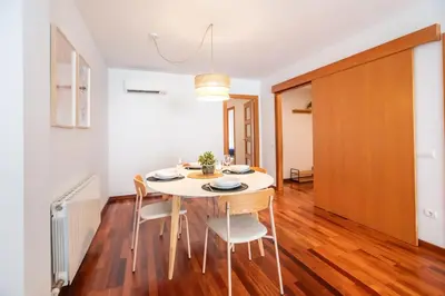 a dining room with a white table and chairs at Mai&Maud Fira Apartment in Hospitalet de Llobregat