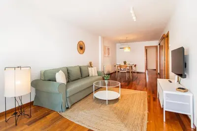 a living room with a green couch and a table at Mai&Maud Fira Apartment in Hospitalet de Llobregat