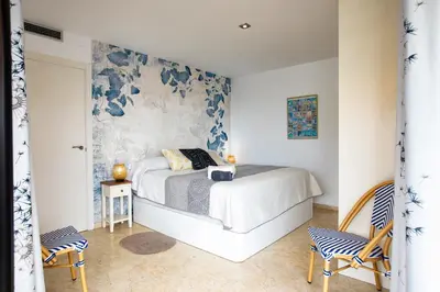 a bedroom with a bed and a wall with flowers at Sunset Penthouse in Sitges