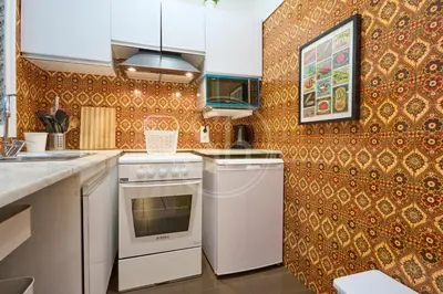 a kitchen with a white stove top oven next to a wall at Acogedor apartamento en Barcelona in Barcelona