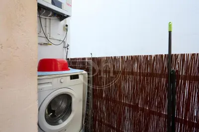 a washing machine with a red hat on top of it at Acogedor apartamento en Barcelona in Barcelona