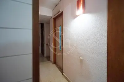 a hallway with a door and a light on the wall at Acogedor apartamento en Barcelona in Barcelona