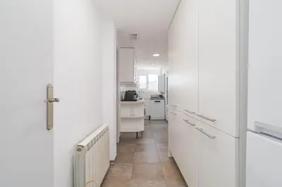 a kitchen with white cabinets and a tile floor at Bright Apt With Amazing Views in Barcelona
