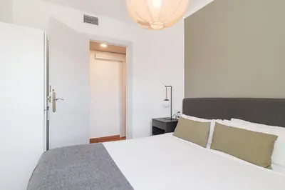 a white bedroom with a white bed with pillows at Bright Apt With Amazing Views in Barcelona