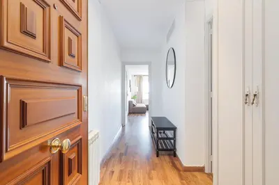 a hallway with a wooden door and a living room at Bright Apt With Amazing Views in Barcelona