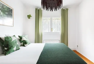 a bedroom with a bed with green curtains and a window at Casa Feliz del Mar in San Pol de Mar